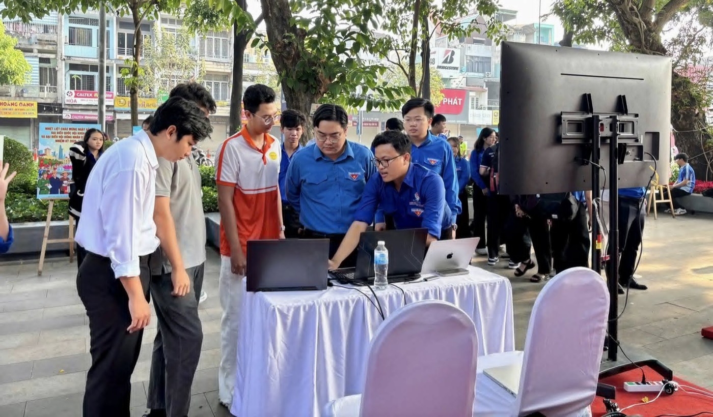 Students and Youth Union volunteers gathered around laptops at the election assistant booth in Water Drop Park